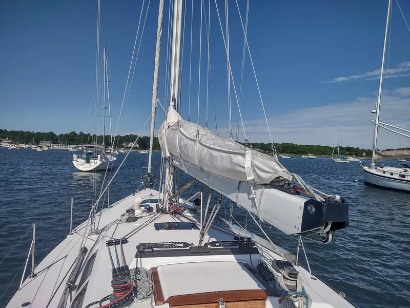 Slide: The Image of 1983 Islander 40 sailboat docked in a serene marina. - 10