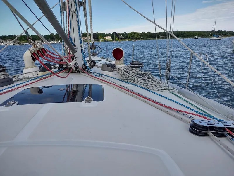 Slide: The Image of 1983 Islander 40 sailboat deck with rigging and ropes on a calm lake. - 14