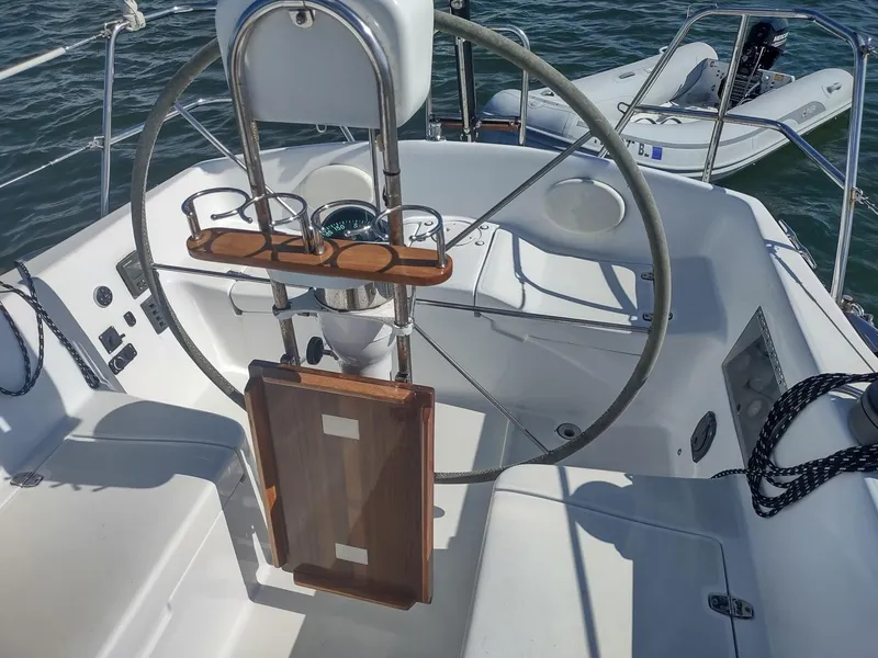 Slide: The Image of Cockpit of 1983 Islander 40 sailboat with steering wheel and wooden table. - 18