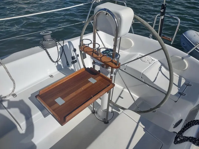 Slide: The Image of Cockpit of 1983 Islander 40 sailboat with wooden table and steering wheel. - 19