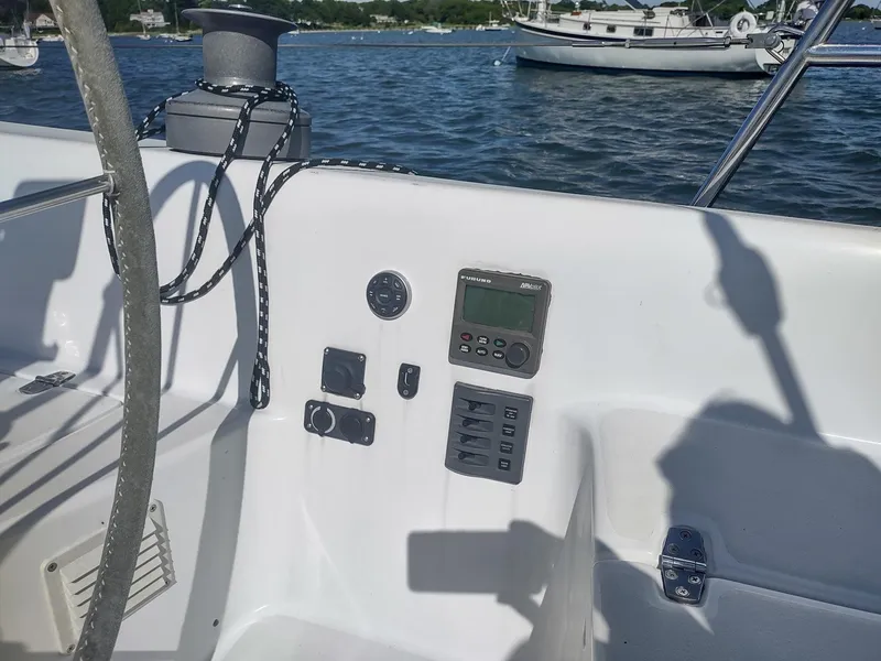 Slide: The Image of Cockpit controls of a 1983 Islander 40 sailboat with a scenic water backdrop. - 21
