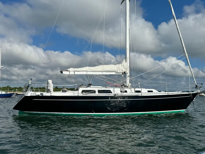 Slide: The Image of 1983 Islander 40 sailboat on calm water with a cloudy sky background. - 3