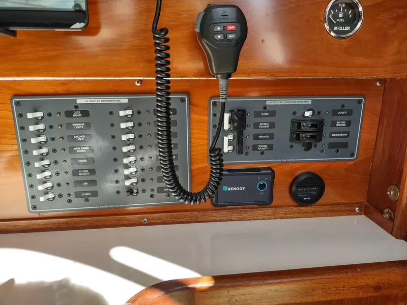 Slide: The Image of Control panel of a 1983 Islander 40 sailboat with various switches and a microphone. - 32