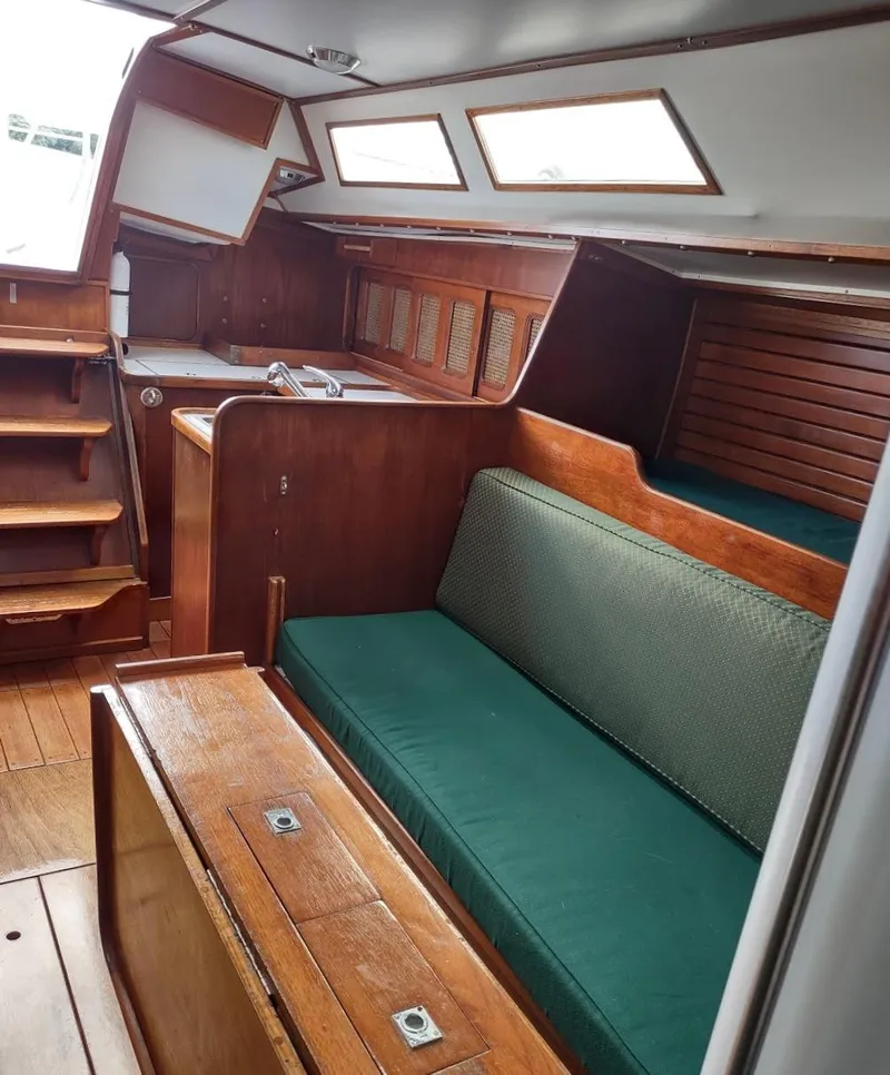 Slide: The Image of Interior of 1983 Islander 40 sailboat with green cushions and wooden finishes. - 36