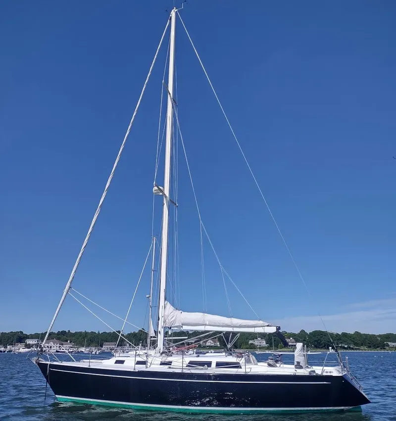 Slide: The Image of 1983 Islander 40 sailboat on calm water under clear blue sky. - 4