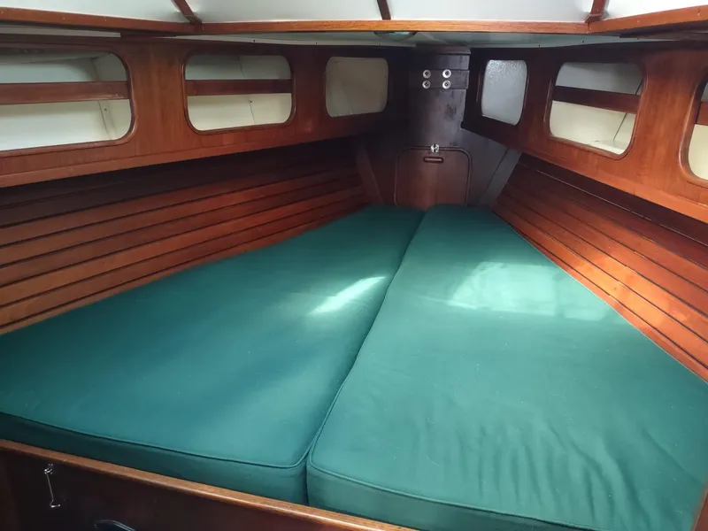 Slide: The Image of Interior cabin of 1983 Islander 40 sailboat with green cushions and wooden paneling. - 47