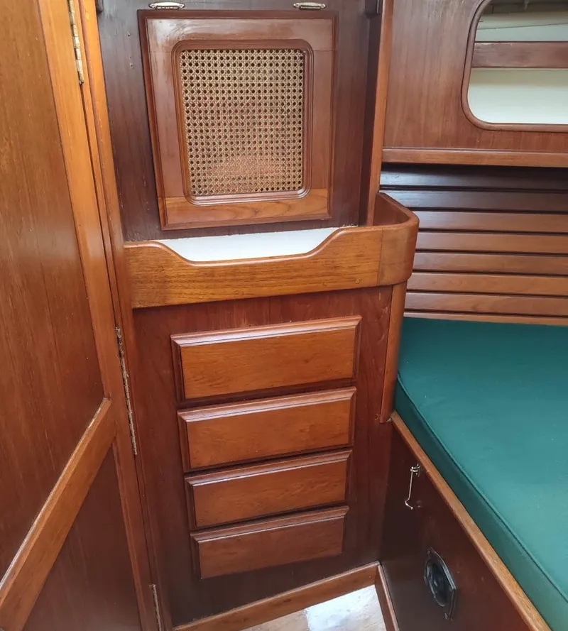 Slide: The Image of 1983 Islander 40 sailboat interior with wooden cabinetry and green cushion. - 48