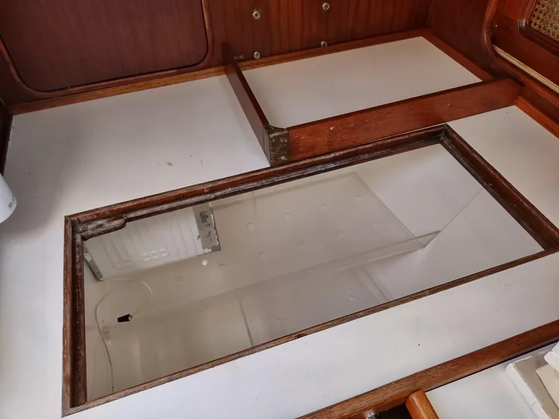 Slide: The Image of Open storage compartment on 1983 Islander 40 sailboat with wooden trim. - 49