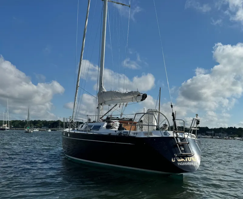 Slide: The Image of 1983 Islander 40 sailboat anchored in a serene harbor. - 8