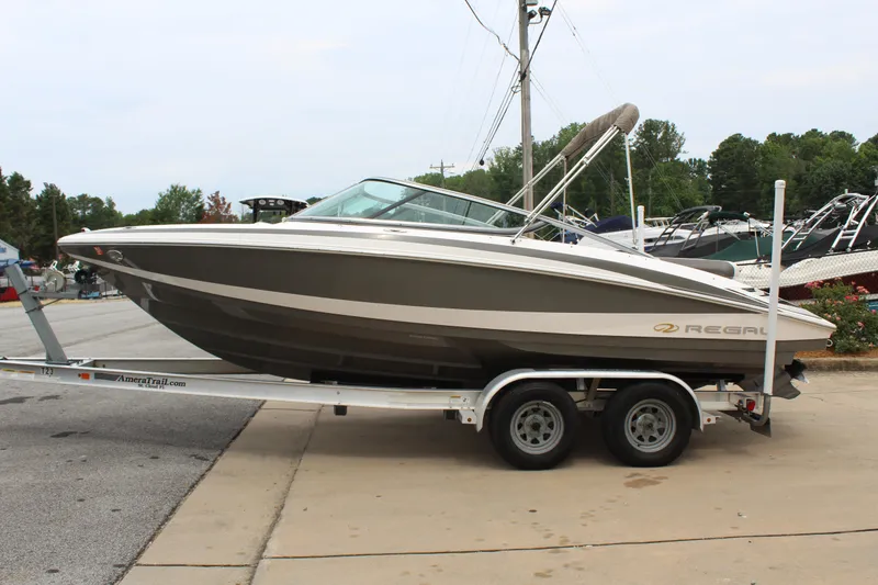 Slide: The Image of 2011 Regal 2100 boat on a trailer in a marina. - 1