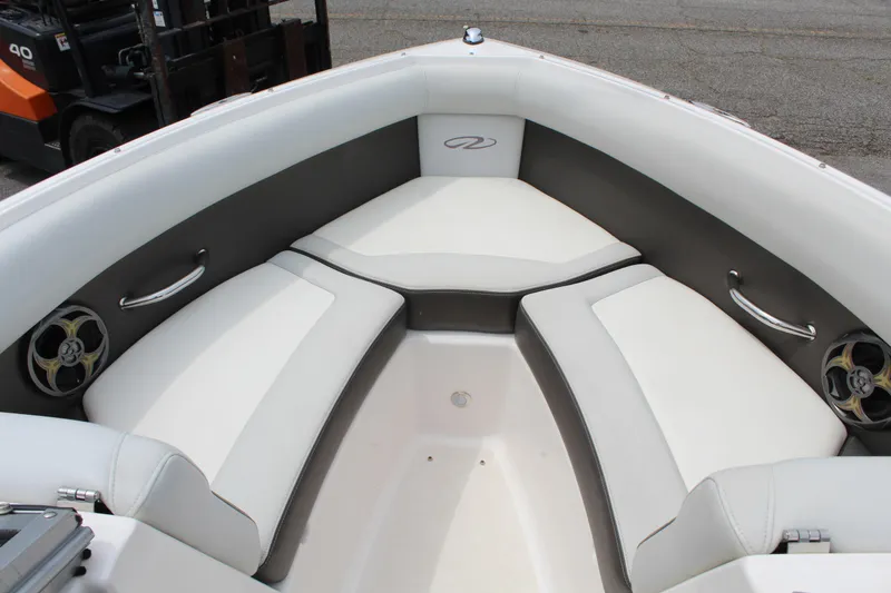 Slide: The Image of 2011 Regal 2100 boat interior with white cushioned seating and stainless steel handles. - 17