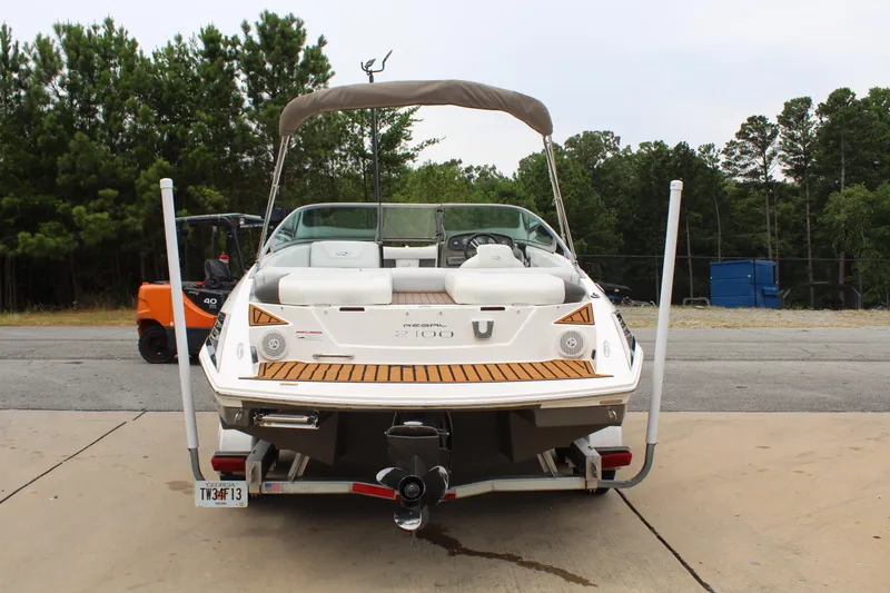 Slide: The Image of 2011 Regal 2100 boat on trailer, rear view, parked outdoors. - 4