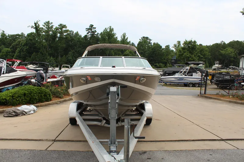 Slide: The Image of 2011 Regal 2100 boat on trailer in a marina setting. - 5