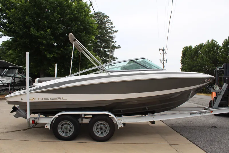 Slide: The Image of 2011 Regal 2100 boat on trailer, parked outdoors, side view. - 6