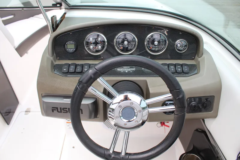 Slide: The Image of Steering wheel and dashboard of a 2011 Regal 2100 boat, featuring gauges and controls. - 9