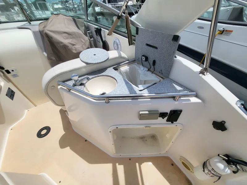 Slide: The Image of 2003 Rinker Fiesta Vee 270 boat interior with kitchenette and seating area. - 17