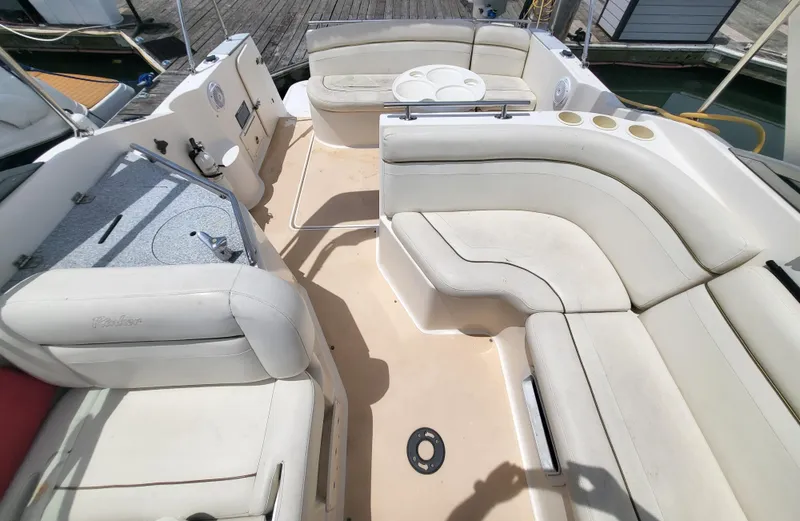 Slide: The Image of 2003 Rinker Fiesta Vee 270 boat interior with beige seating and table. - 18