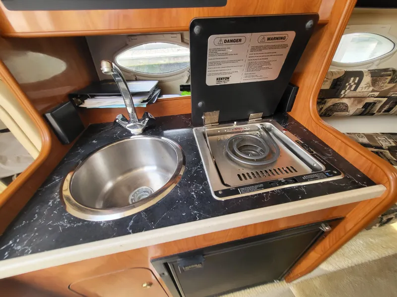 Slide: The Image of 2003 Rinker Fiesta Vee 270 boat kitchenette with sink and stove. - 27