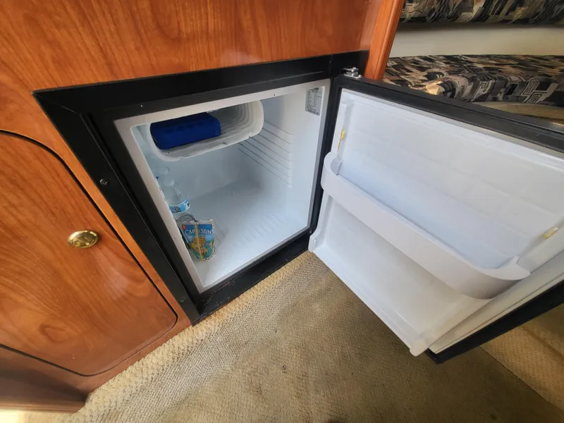 Slide: The Image of Open mini fridge inside 2003 Rinker Fiesta Vee 270 boat cabin. - 28