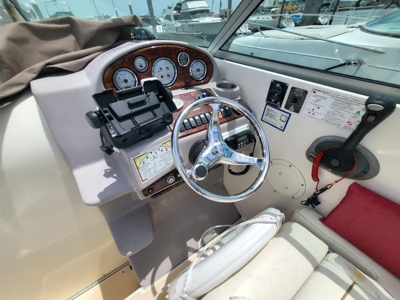 Slide: The Image of 2003 Rinker Fiesta Vee 270 boat dashboard with steering wheel and control panel. - 4