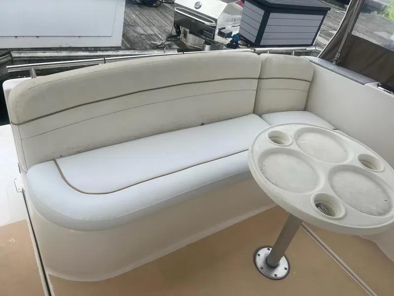 Slide: The Image of 2003 Rinker Fiesta Vee 270 boat interior with white seating and round table. - 5