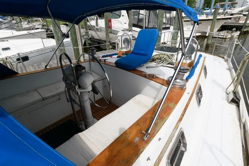 Slide: The Image of 1977 Gulfstar 50 Center Cockpit sailboat with blue canopy and wooden trim. - 13