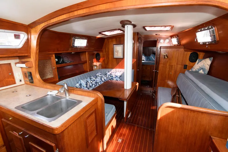 Slide: The Image of 1977 Gulfstar 50 Center Cockpit interior with wooden finishes, kitchen sink, and seating area. - 16