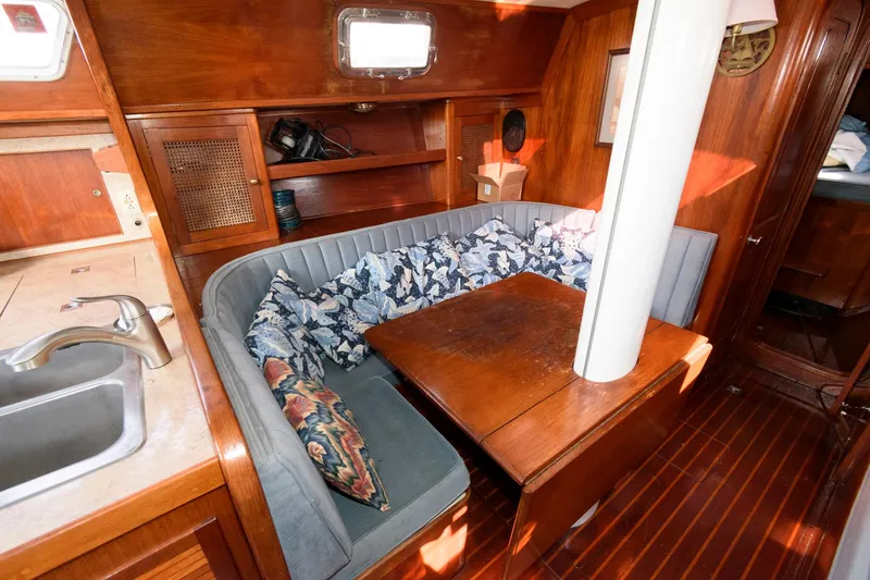 Slide: The Image of 1977 Gulfstar 50 Center Cockpit interior with cozy dining area and wooden finishes. - 17