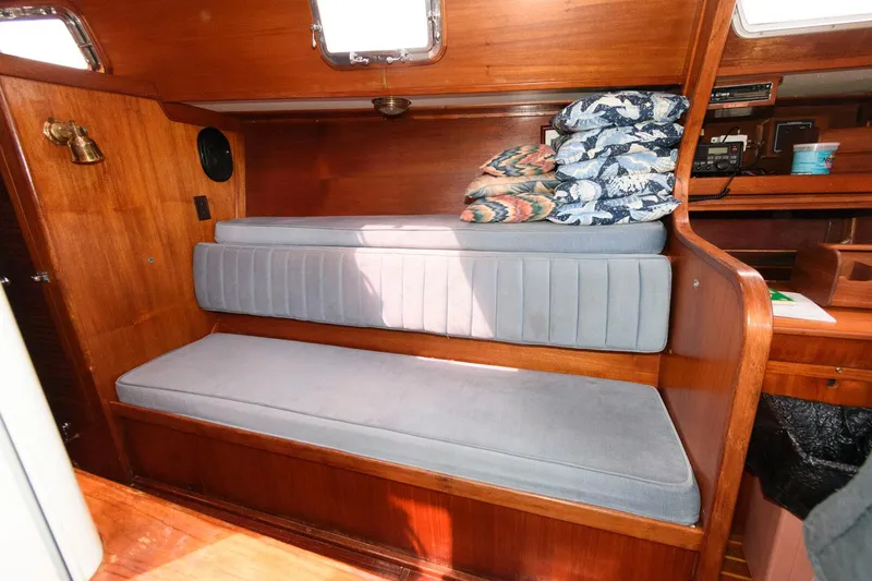 Slide: The Image of 1977 Gulfstar 50 Center Cockpit interior with cushioned seating and wooden finish. - 22