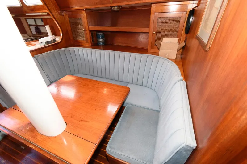 Slide: The Image of 1977 Gulfstar 50 Center Cockpit interior with wooden table and blue cushioned seating. - 23