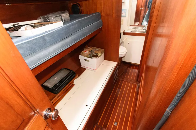 Slide: The Image of 1977 Gulfstar 50 Center Cockpit interior with wooden cabinetry, bunk bed, and bathroom. - 27