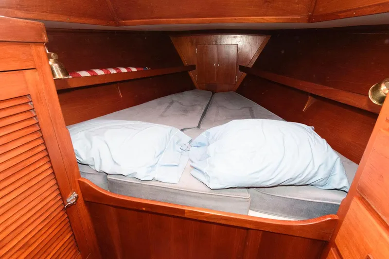 Slide: The Image of 1977 Gulfstar 50 Center Cockpit boat cabin with cozy bed and wooden interior. - 29