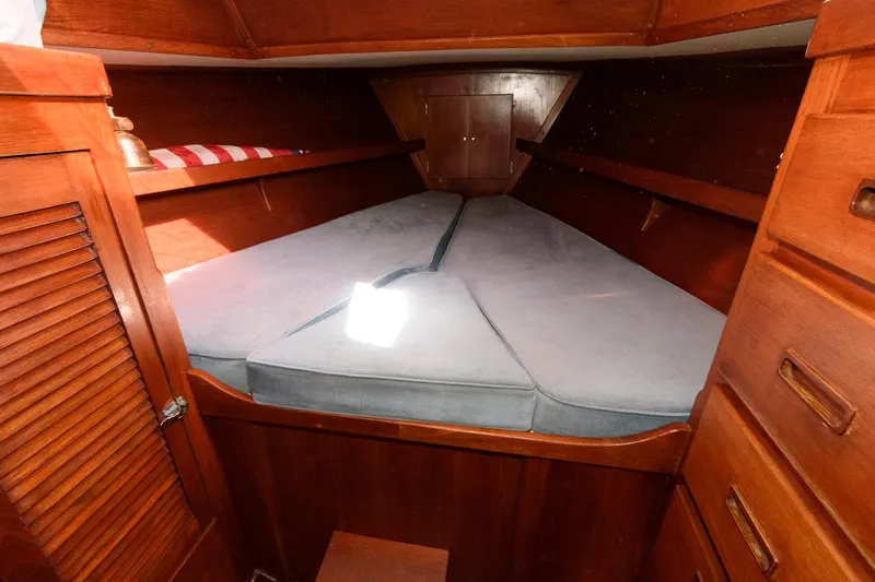 Slide: The Image of 1977 Gulfstar 50 Center Cockpit V-berth cabin with wooden cabinetry and cushioned bed. - 36