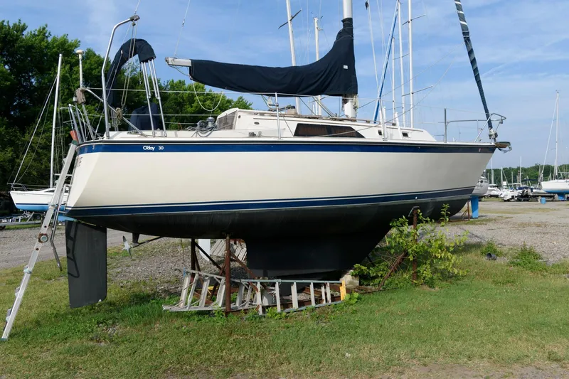 Slide: The Image of 1983 O'Day 30 sailboat on dry dock, covered mainsail, marina background. - 1