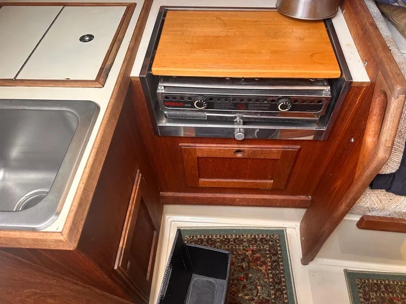 Slide: The Image of Compact kitchen area in 1983 O'Day 30 sailboat with stove, sink, and wooden cabinetry. - 11