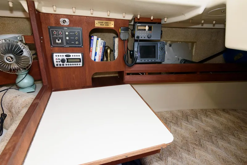 Slide: The Image of Navigation station inside 1983 O'Day 30 sailboat with electronics and books. - 15