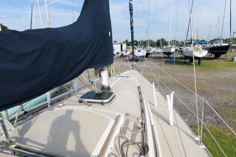 Slide: The Image of 1983 O'Day 30 sailboat on land, covered mast, marina background. - 7