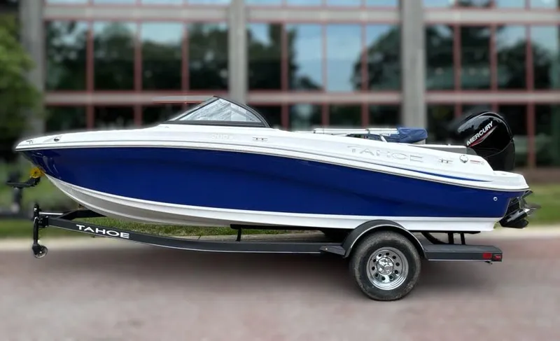 Slide: The Image of 2024 Tahoe 200 S boat on trailer, blue and white exterior, parked outdoors. - 0