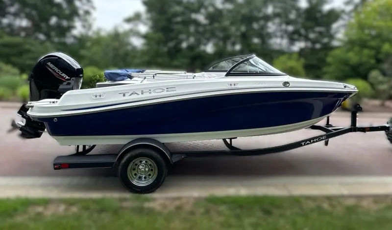 Slide: The Image of 2024 Tahoe 200 S boat on a trailer, blue and white exterior. - 1