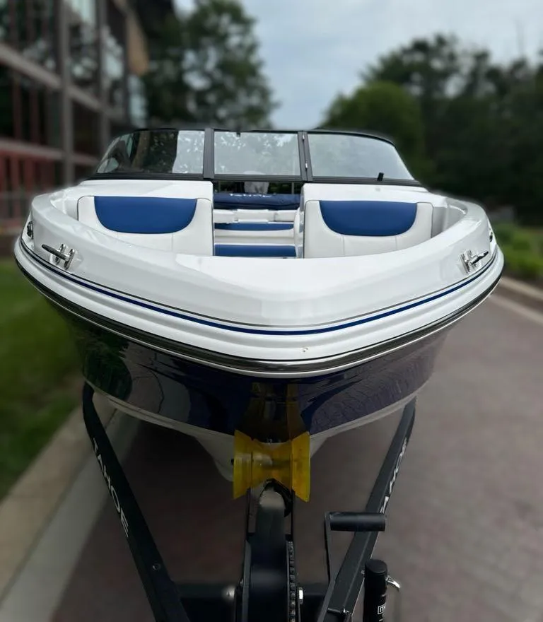 Slide: The Image of 2024 Tahoe 200 S boat with blue and white seating on a trailer. - 2