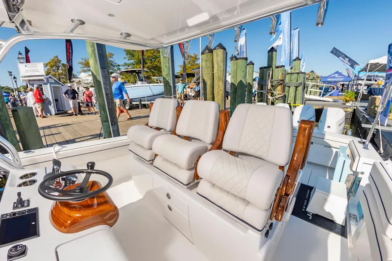 Slide: The Image of 2025 Valhalla Boatworks V-41 interior with luxurious seating and modern helm at a marina. - 10