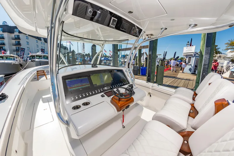 Slide: The Image of 2025 Valhalla Boatworks V-41 helm with modern controls and luxurious seating at a marina. - 12