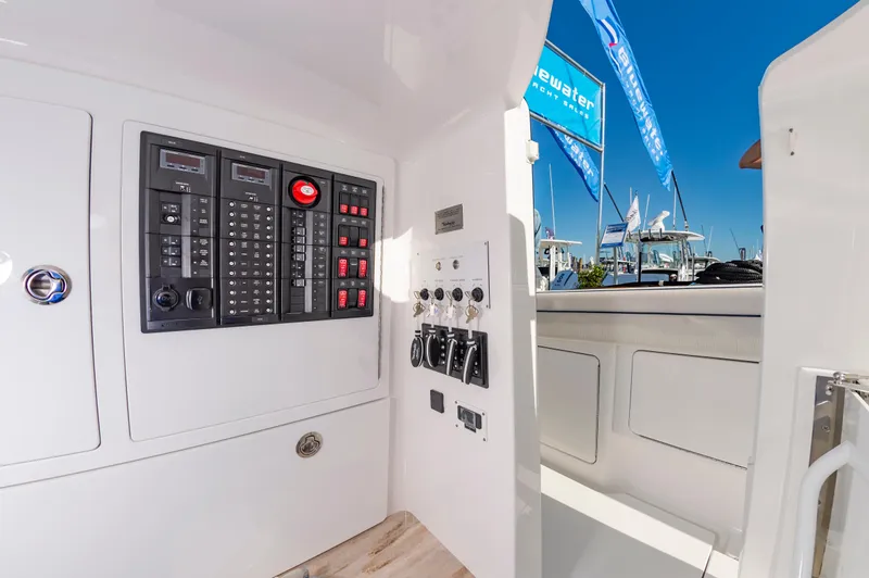 Slide: The Image of 2025 Valhalla Boatworks V-41 control panel with switches and gauges, docked under clear blue sky. - 21