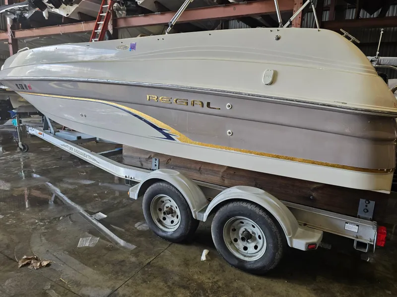 Slide: The Image of 1999 Regal Destiny 200 boat on a trailer in a storage facility. - 2
