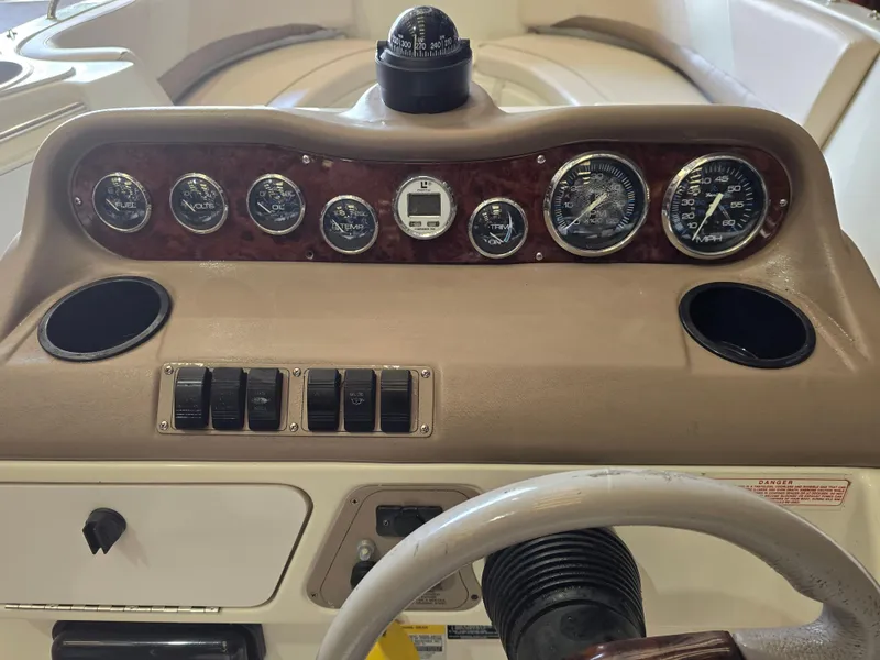 Slide: The Image of 1999 Regal Destiny 200 boat dashboard with gauges, switches, and compass. - 6