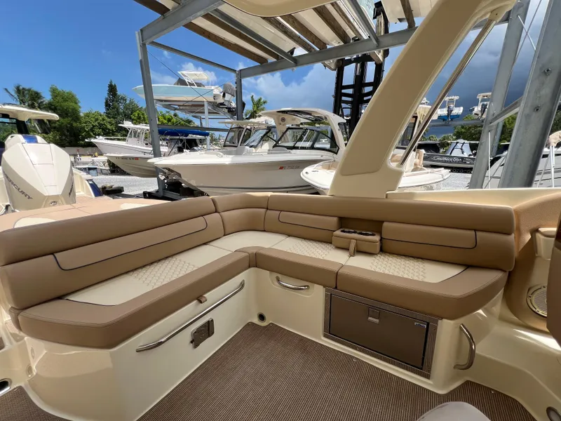 Slide: The Image of 2024 Chris-Craft Launch 25 GT interior with tan leather seating, docked at marina. - 10