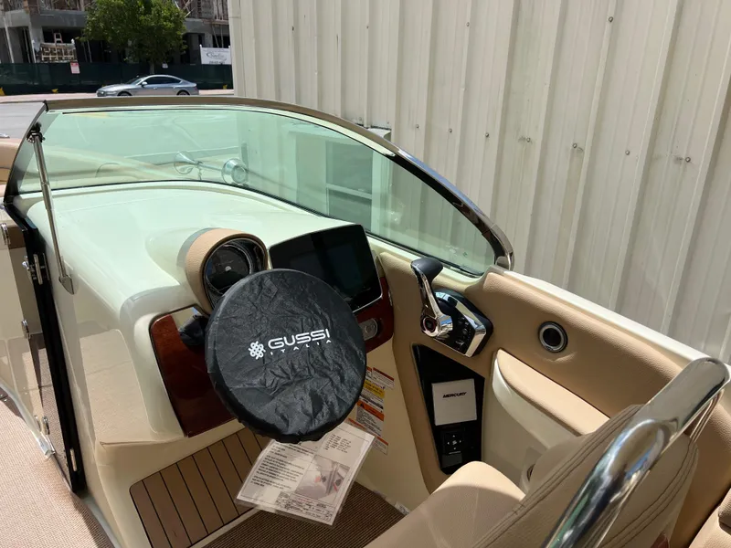 Slide: The Image of 2024 Chris-Craft Launch 25 GT boat cockpit with Gussi steering wheel and modern dashboard. - 12