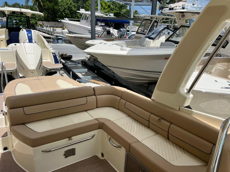 Slide: The Image of 2024 Chris-Craft Launch 25 GT luxury boat with beige seating, docked among other boats. - 9