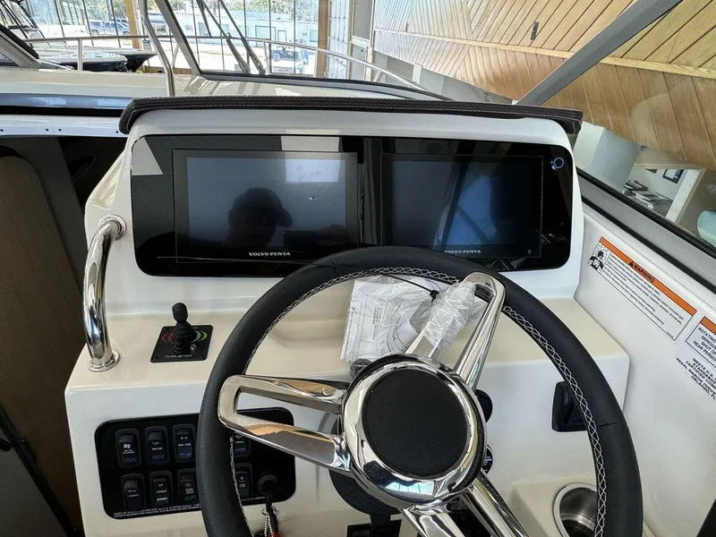 Slide: The Image of 2025 Regal 28X boat dashboard with dual Volvo Penta displays and steering wheel. - 12