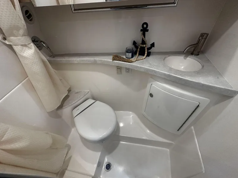 Slide: The Image of Compact bathroom in 2025 Regal 28X boat with modern fixtures and nautical decor. - 13